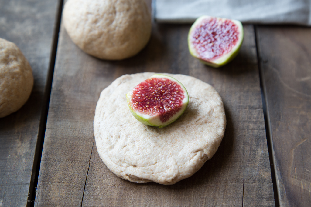 Kadota fig being stuffed into a whole grain roll. 